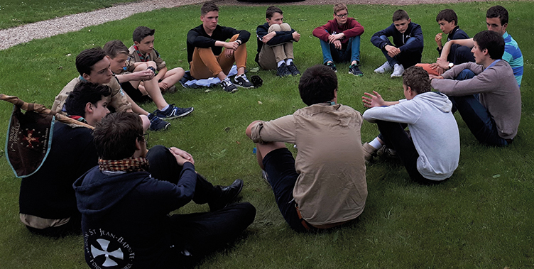 jeunes hommes écoutant une conférence jeunes assis par terre