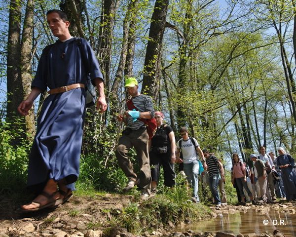 prêtre discutant avec un jeune lors d'une promenade en forêt